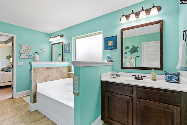 ensuite bathroom with a garden tub, baseboards, and vanity