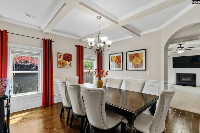 dining space featuring hardwood / wood-style floors, arched walkways, beam ceiling, coffered ceiling, and ceiling fan