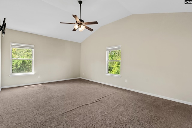 empty room featuring lofted ceiling, carpet, baseboards, and ceiling fan