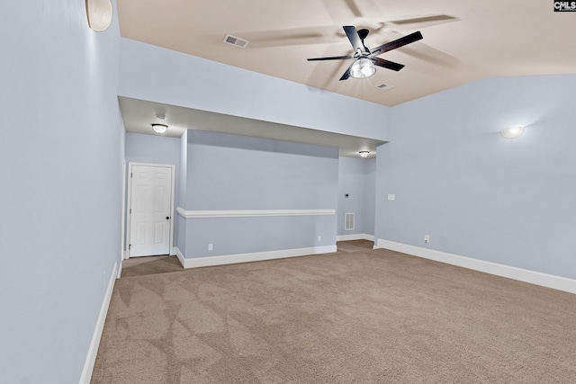 carpeted spare room featuring a ceiling fan, baseboards, and vaulted ceiling