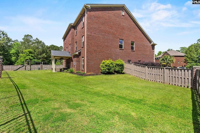 view of side of home with brick siding and a playground