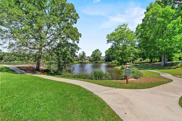 view of community with a water view and a lawn