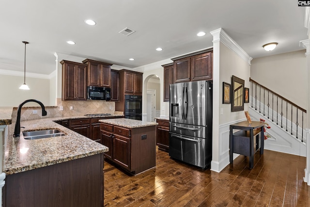 kitchen with black appliances, a sink, ornamental molding, a peninsula, and arched walkways
