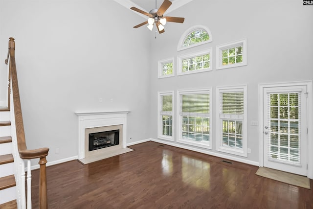 5 Stonewall Ct, Irmo, SC 29063 - unfurnished living room featuring a high ceiling, a ceiling fan, wood finished floors, healthy amount of natural light, and a fireplace with flush hearth