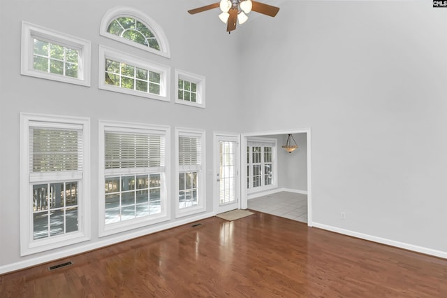 5 Stonewall Ct, Irmo, SC 29063 - unfurnished living room featuring ceiling fan, a towering ceiling, wood finished floors, and baseboards
