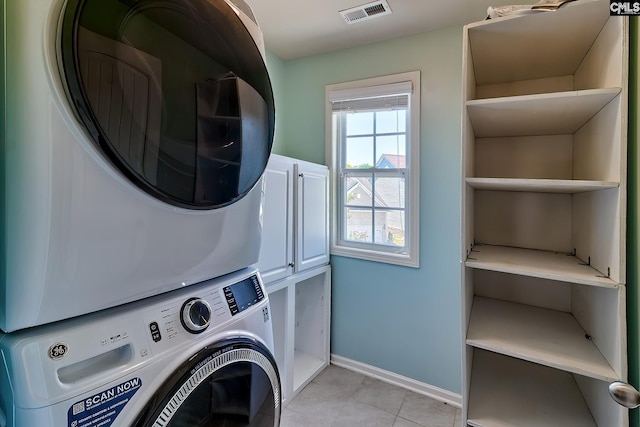64 Downing Cir, Gilbert, SC 29054 - laundry area with estacked washer and dryer, cabinet space, and light tile patterned floors