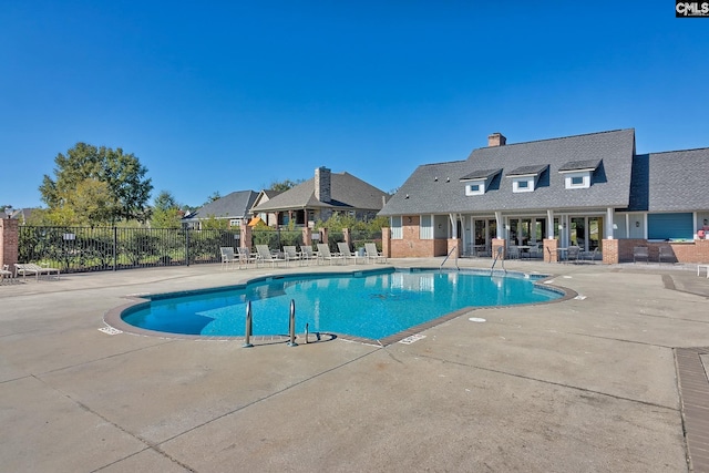 community pool featuring a patio and fence