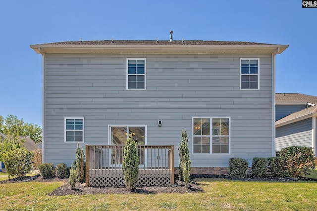 back of property featuring a deck and a yard