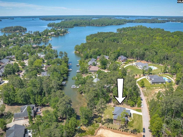 aerial view of property's location with a nearby body of water, a forest, and nearby suburban area