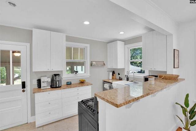 3803 Yale Ave, Columbia, SC 29205 - kitchen with a sink, a kitchen bar, light stone counters, white cabinets, and a peninsula
