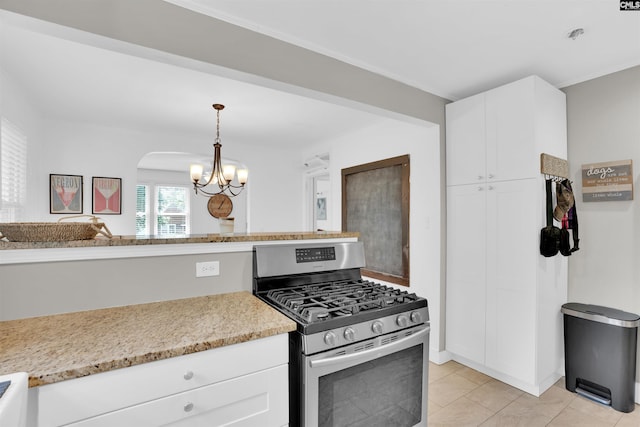 3803 Yale Ave, Columbia, SC 29205 - kitchen featuring gas range, a chandelier, white cabinets, light tile patterned floors, and decorative light fixtures