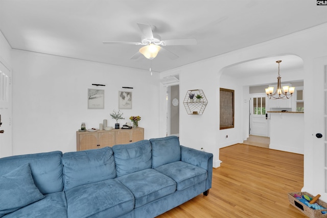 3803 Yale Ave, Columbia, SC 29205 - living room featuring arched walkways, a chandelier, light wood finished floors, a ceiling fan, and baseboards