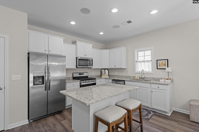 255 Honey Hill Way, Blythewood, SC 29016 - kitchen with appliances with stainless steel finishes, a sink, white cabinetry, a center island, and a breakfast bar area