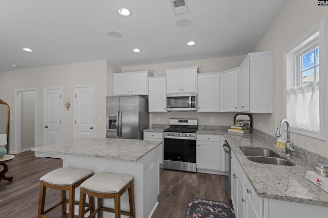 255 Honey Hill Way, Blythewood, SC 29016 - kitchen with stainless steel appliances, a sink, a center island, a breakfast bar area, and white cabinets