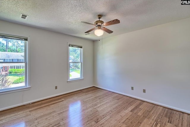empty room featuring wood finished floors, a ceiling fan, a textured ceiling, and baseboards