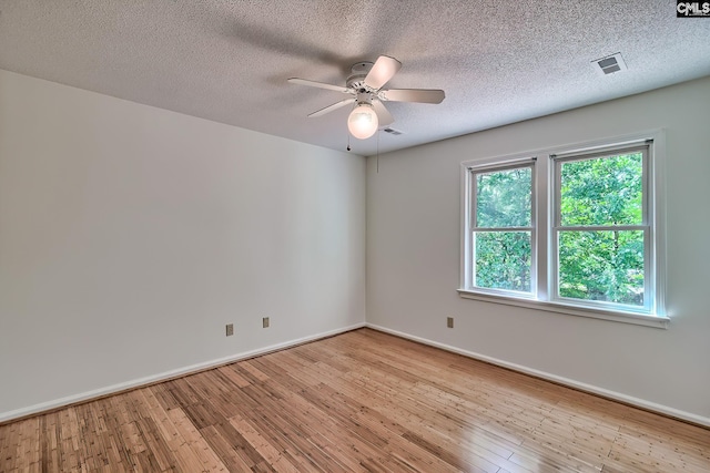 empty room with wood finished floors, ceiling fan, baseboards, and a textured ceiling