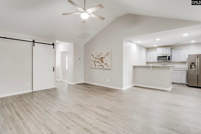 146 Sabal Dr, West Columbia, SC 29169 - unfurnished living room with a barn door, ceiling fan, high vaulted ceiling, light wood-style flooring, and baseboards
