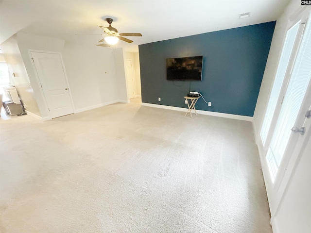 unfurnished living room with ceiling fan, baseboards, and carpet floors
