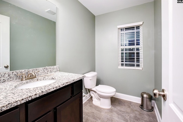 bathroom with baseboards, toilet, vanity, and tile patterned flooring