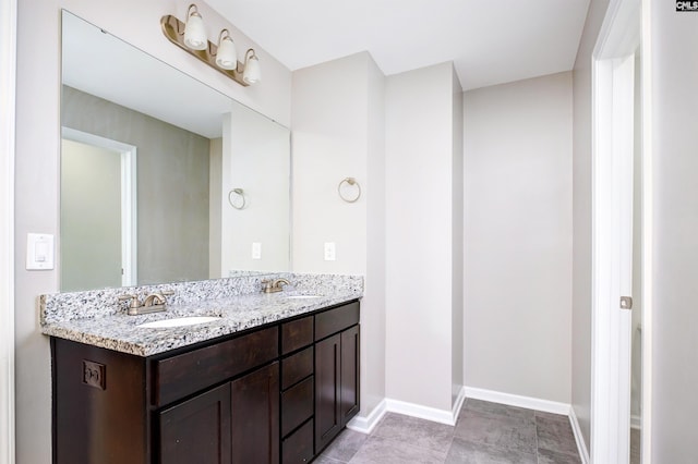 full bathroom with double vanity and baseboards