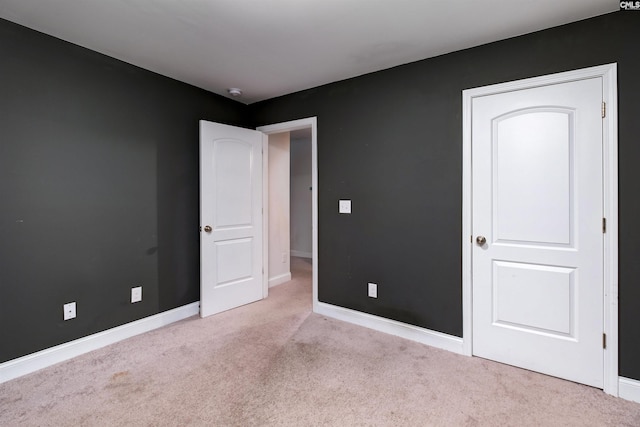 unfurnished bedroom with carpet flooring and baseboards
