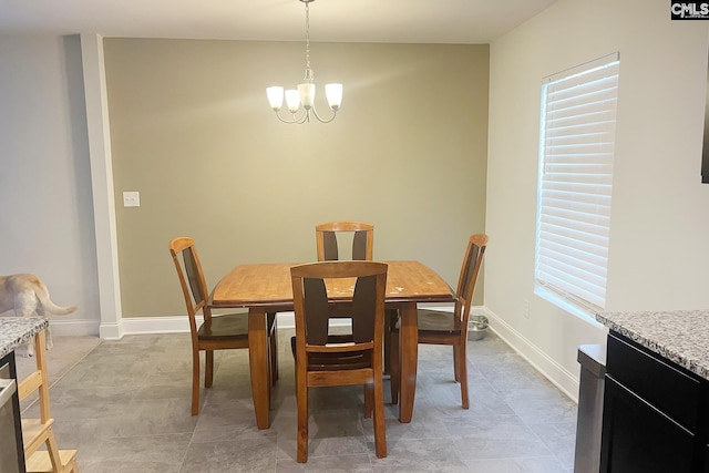 dining space with a chandelier and baseboards