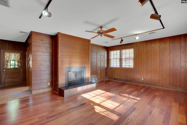 604 Shady Ln, Cayce, SC 29033 - unfurnished living room with track lighting, a fireplace, hardwood / wood-style flooring, healthy amount of natural light, and wooden walls