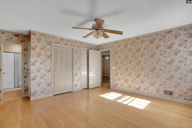 604 Shady Ln, Cayce, SC 29033 - unfurnished bedroom featuring light wood finished floors, two closets, baseboards, ornamental molding, and ensuite bath