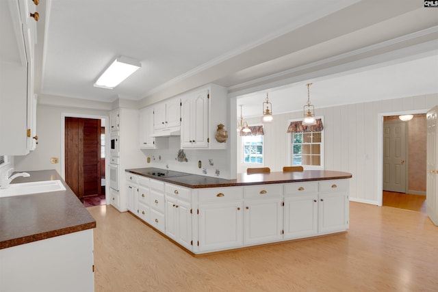 604 Shady Ln, Cayce, SC 29033 - kitchen with a sink, dark countertops, white appliances, light wood-type flooring, and white cabinetry
