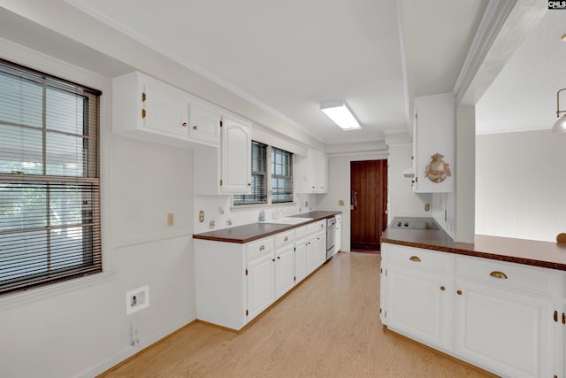 604 Shady Ln, Cayce, SC 29033 - kitchen with dark countertops, light wood-style flooring, plenty of natural light, white cabinets, and crown molding