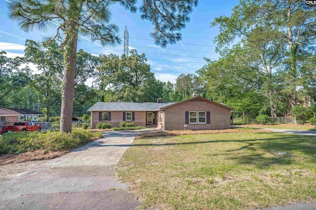 604 Shady Ln, Cayce, SC 29033 - ranch-style house featuring concrete driveway, brick siding, a chimney, and view of wooded area