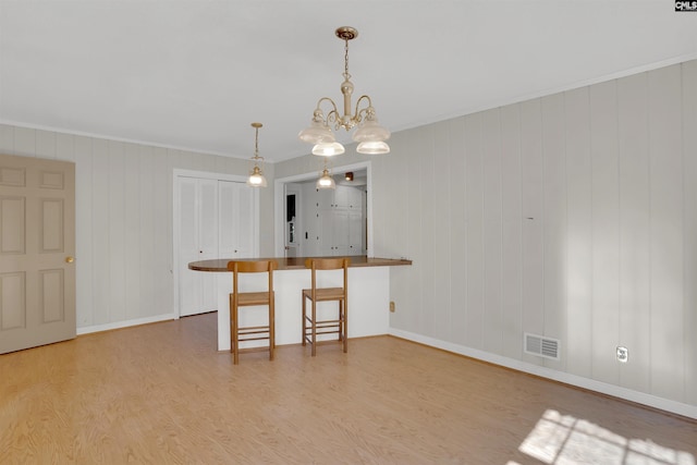 604 Shady Ln, Cayce, SC 29033 - kitchen with light wood-style floors, ornamental molding, a chandelier, baseboards, and decorative light fixtures