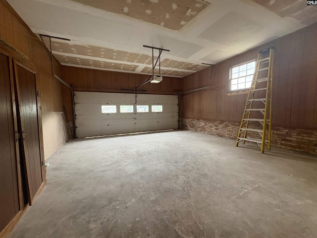 garage with a garage door opener and wood walls