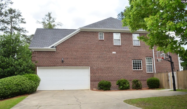 5102 Circle Dr, Columbia, SC 29206 - view of side of home featuring concrete driveway, fence, brick siding, a garage, and roof with shingles