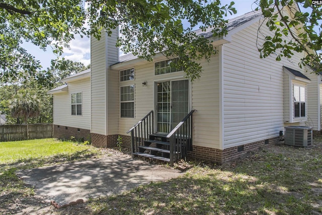 back of property featuring crawl space, entry steps, fence, a patio, and central AC