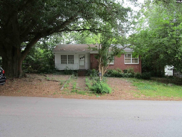 view of front of house with a porch and brick siding