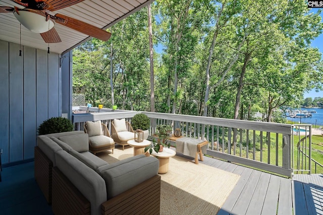 wooden deck featuring ceiling fan and a water view