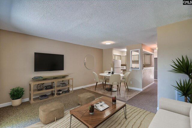 carpeted living area featuring a textured ceiling and baseboards