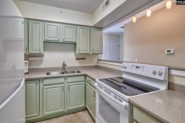 kitchen featuring electric stove, a sink, green cabinetry, and a textured ceiling