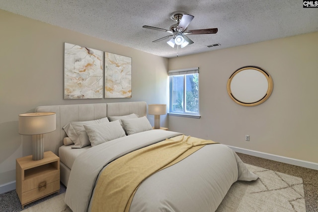 bedroom with a textured ceiling, carpet, baseboards, and a ceiling fan