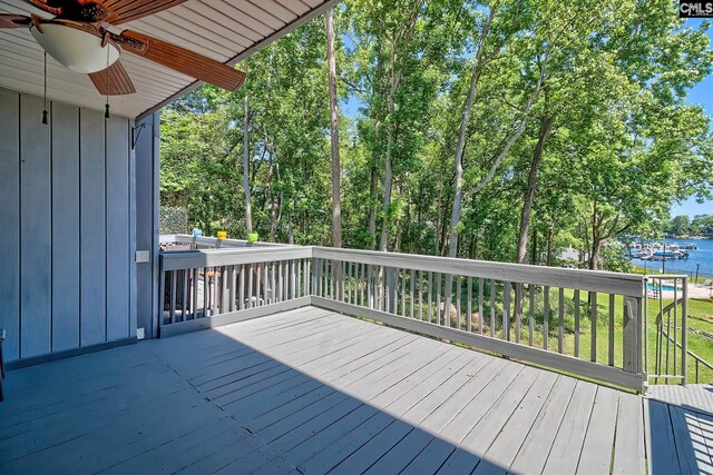 deck with ceiling fan and a water view