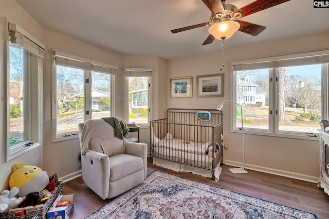bedroom featuring multiple windows, wood finished floors, and baseboards
