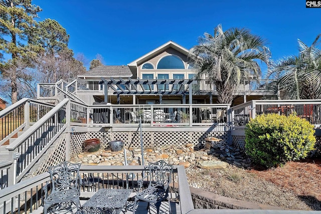 back of property featuring stairway, a deck, a pergola, and a shingled roof