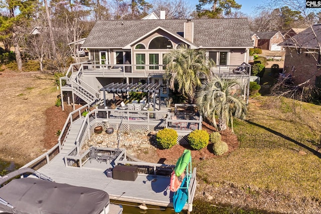 back of house featuring stairs, a shingled roof, a chimney, and a deck