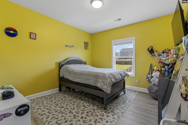 bedroom with baseboards and light wood finished floors