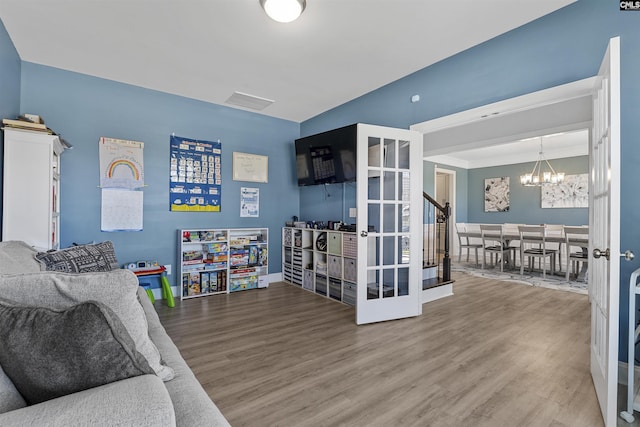 rec room featuring a chandelier and wood finished floors