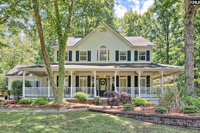 view of front of property with ceiling fan, a porch, and a front yard