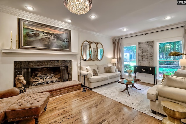 living room with ornamental molding, wood finished floors, a high end fireplace, a chandelier, and recessed lighting