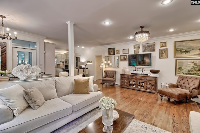 living room featuring a chandelier, crown molding, wood finished floors, and recessed lighting