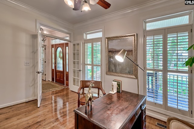 office space with a ceiling fan, light wood finished floors, crown molding, french doors, and baseboards